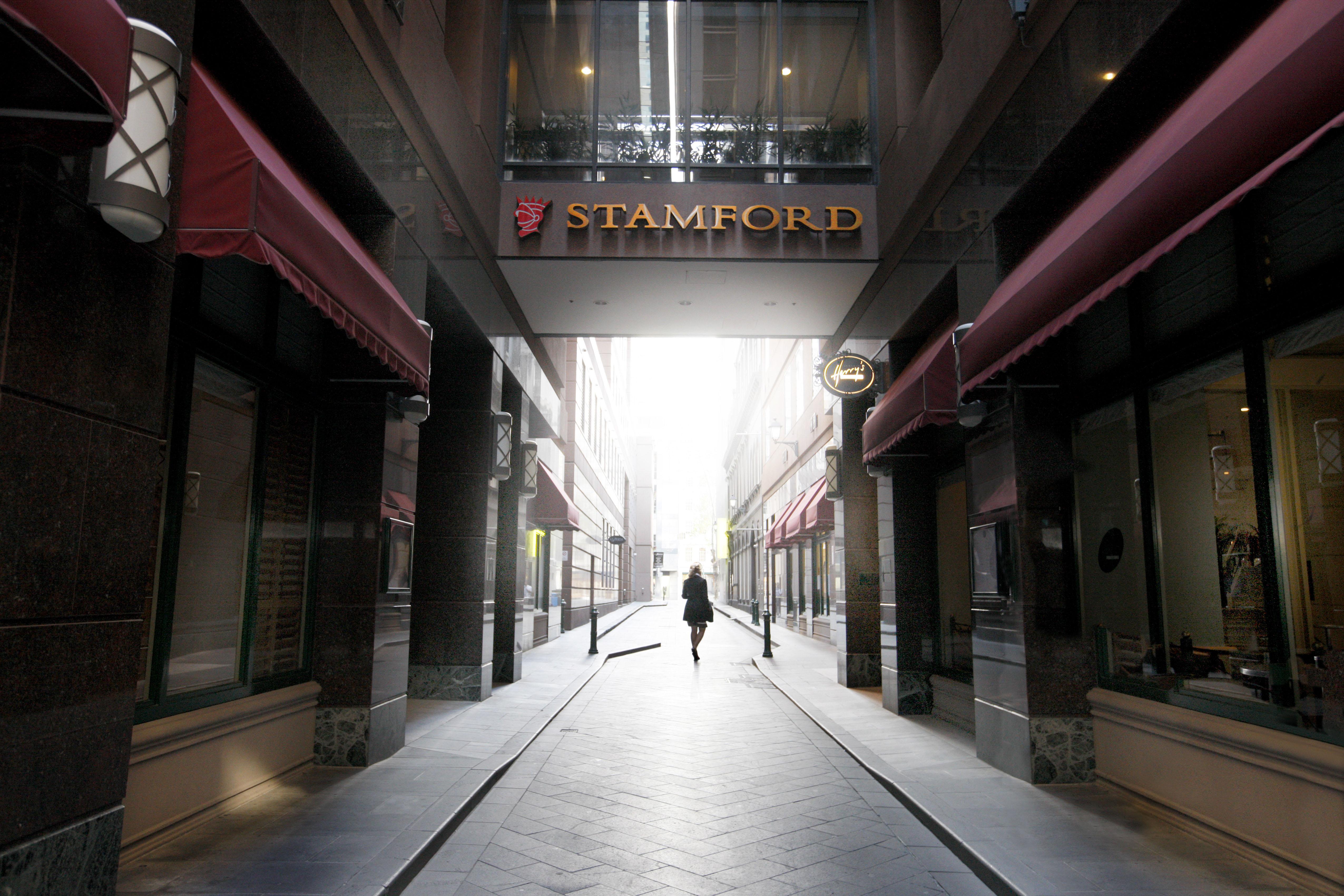 墨尔本斯坦福广场酒店 外观 照片 The photo depicts a narrow alley or passageway, possibly in an urban setting. On one side, there are storefronts with canopies, and on the opposite side, there is a prominent sign reading "STAMFORD." The pathway is lined with buildings, creating a se